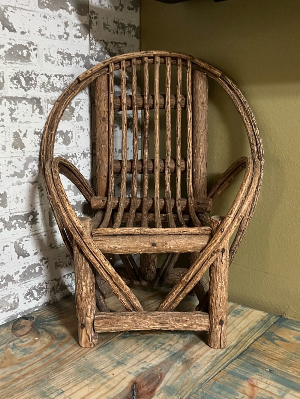 Primitive bentwood willow twig chair with a rounded back & a slatted wood seat